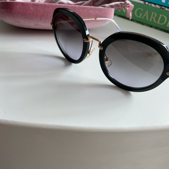 Miu Miu circular glasses in black and gold main image 2